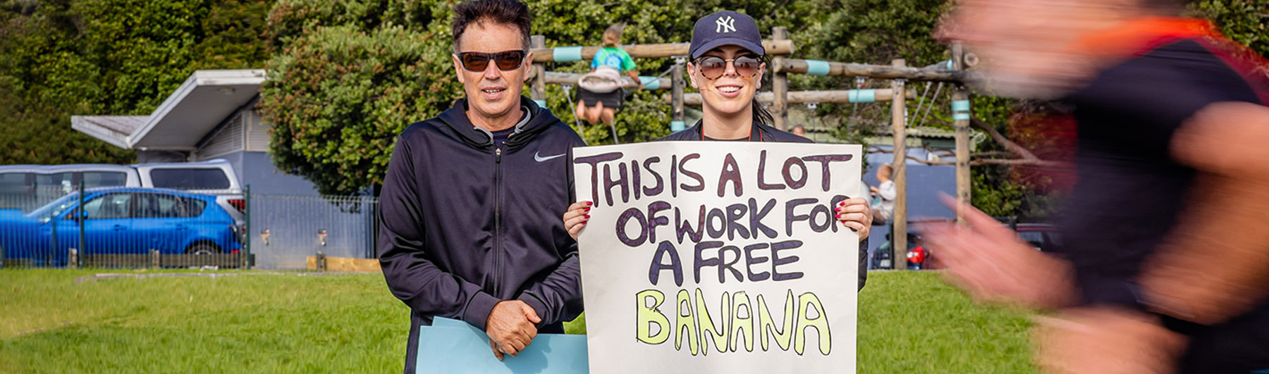 People cheering on athletes with a handmade race-day sign