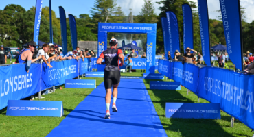 Triathlete running down the blue finish chute at Mission Bay.