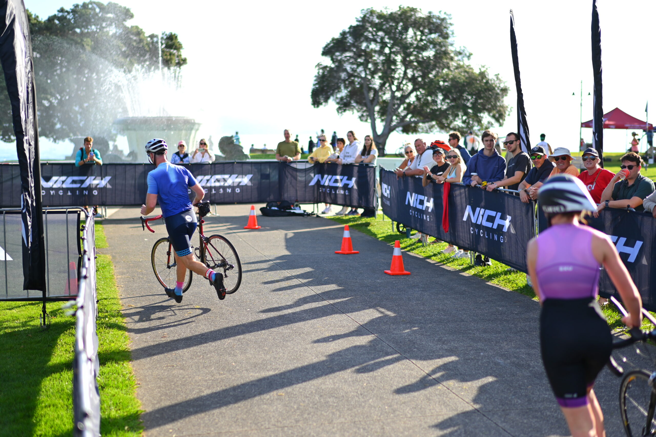 Athletes move through the marked bike transition exit at People’s Triathlon in Mission Bay.